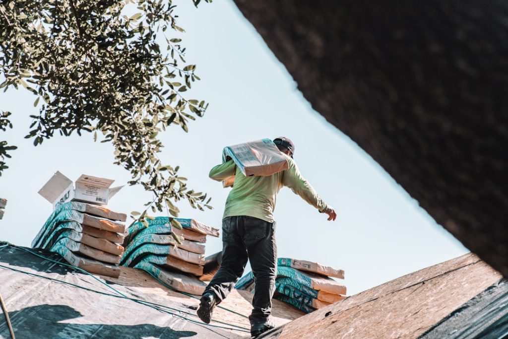 a-man-riding-a-skateboard-on-top-of-a-roof-4xmhsy4rvi8 Construction worker carrying heavy shingles to be installed by the master roofer.