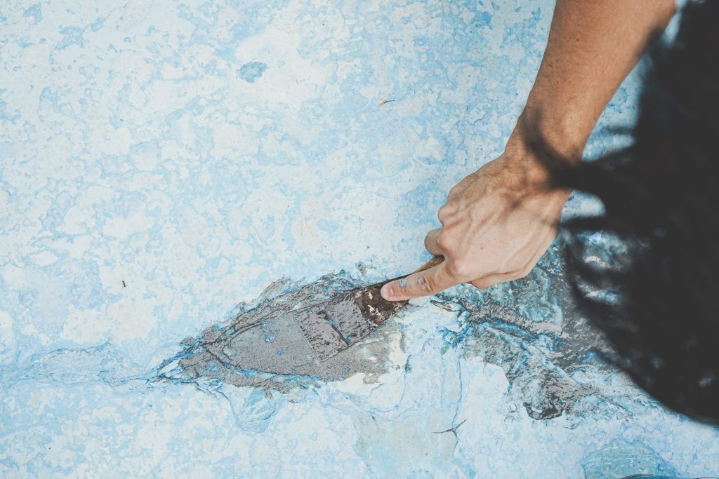 Close up of a man fixing the floor of a pool